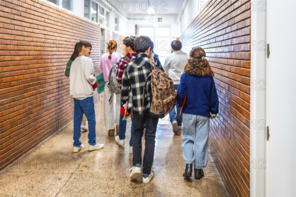 Group of elementary school students walking down the school hallway, chatting and laughing together