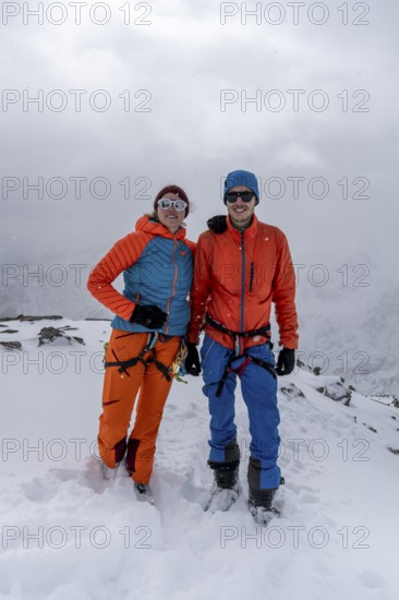 Two ski tourers, couple on the summit of the Köllkuppe or Cima Marmota, snow-covered mountain