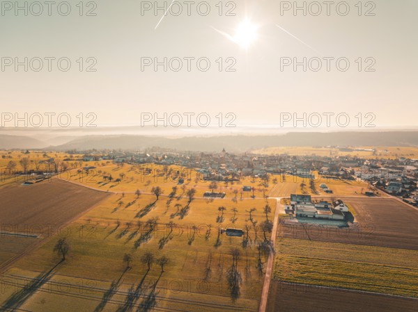 Spacious fields and trees, surrounding a village under bright sunbeams, Neubulach, Black Forest,
