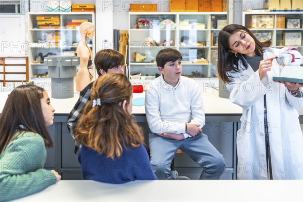 Science teacher engaging high school students with an anatomical model during an interactive