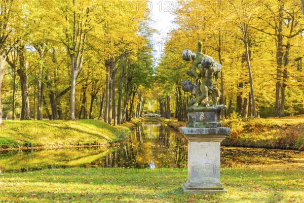 Group of figures in the park of Hermsdorf Castle with castle moat in autumn, Ottendorf-Ockrilla,