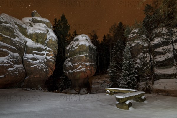 Snow-covered natural monument Kelchsteine at night and snowfall, Oybin, Zittau Mountains, Saxony,