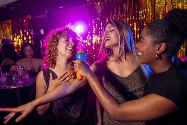 Group of female friends enjoying karaoke night, singing with passion and having fun together in