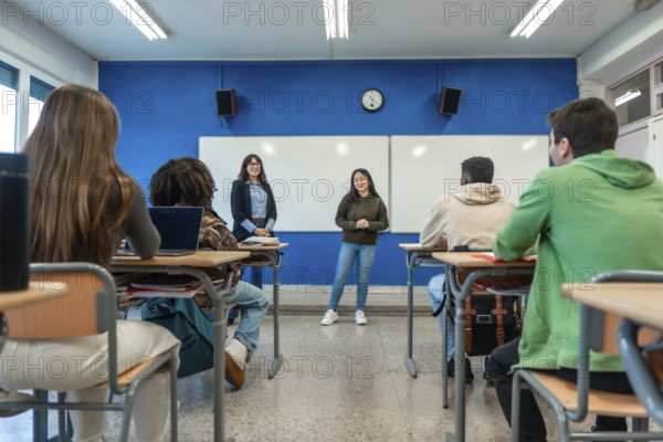 Confident young woman giving a presentation to her classmates and teacher in a modern university