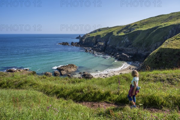A hiker on a coastal path. View of Rose-an Hale Cove. Between Gurnard's Head and Carnelloe Headland