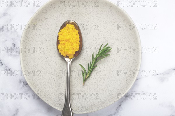Yuzu caviar is pearly, on a spoon, top view, light background, no people.