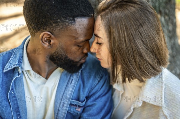 Close up of a beautiful Mixed-race young couple enjoying each other rubbing roses and embracing in