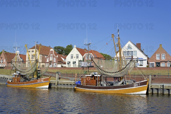 Crab cutter in the harbour in front of historic buildings, blue sky, Greetsiel, North Sea, Lower