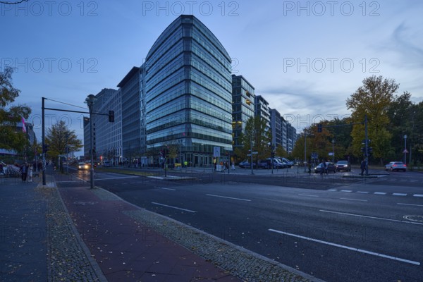 Junction of Lennéstraße with Ebertstraße and glass facade of a commercial building at blue hour in