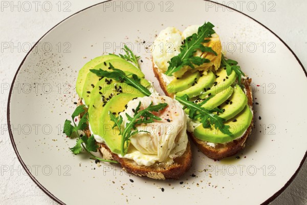 Sandwich with cream cheese, sliced avocado and boiled egg, arugula, on grainy bread, homemade,