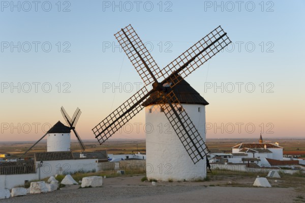White windmills stand in a rural landscape under a gentle morning sky, Campo de Criptana, Ciudad
