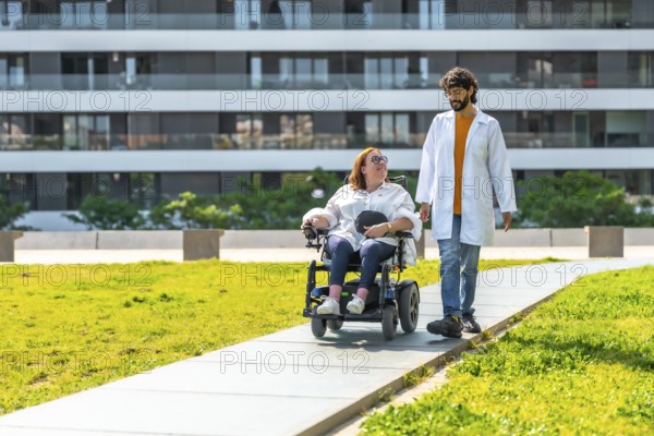 Doctor assisting a female patient in an electric wheelchair, strolling through a sunny park near