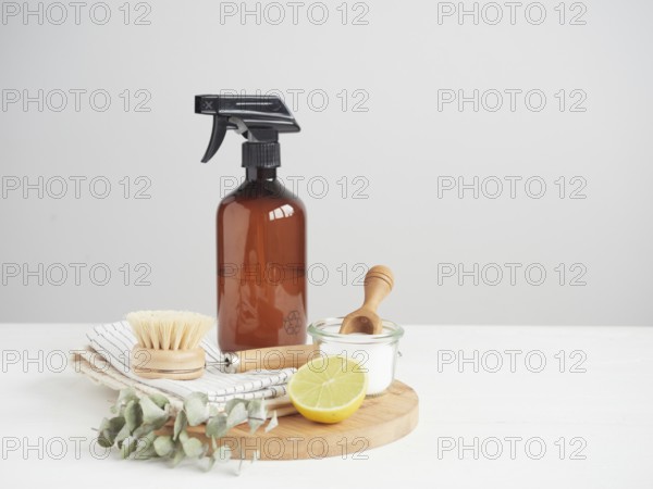 Natural cleaning product in reusable recycled glass bottle. Lemon and baking soda. Natural bristle