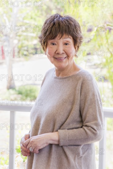 Happy senior chinese woman poses for her portrait outdoors