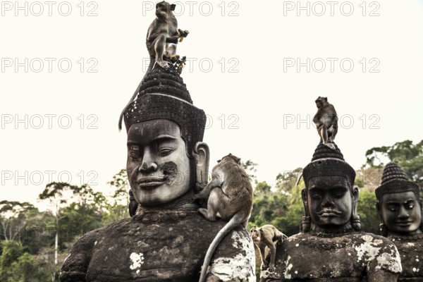 Figures and monkeys on the bridge to Angkor Thom, macaques, sunset, Angkor Wat, Angkor, UNESCO