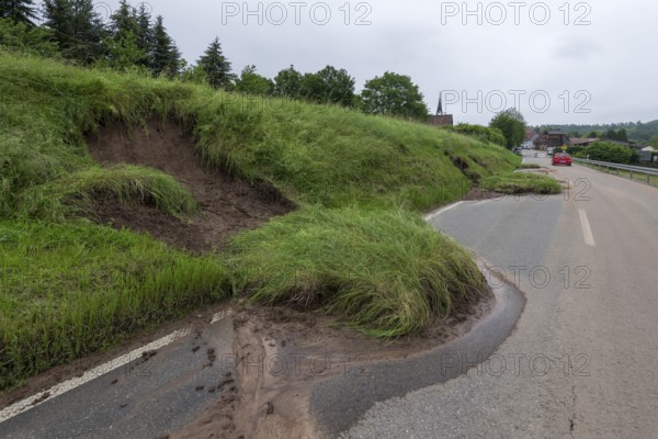 Symbolic image of climate change, slippery slope on a country road after heavy rainfall, near
