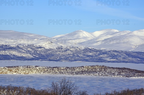 Snow-covered mountains and a frozen lake in a cold winter landscape, Abisko, Abisko National Park,