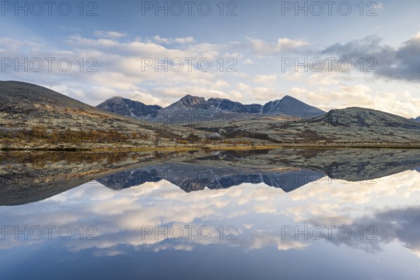 Reflection of the autumn landscape in Rondane National Park, mountains Høgronden, Midtronden and