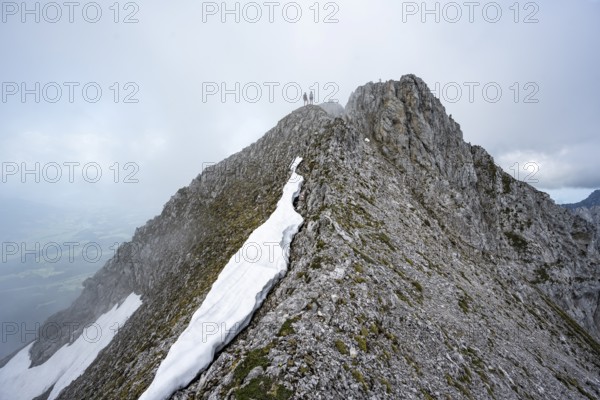 Two mountaineers on the rocky ridge, ascent to the Ackerlspitze, clouds moving around the