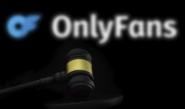 Court gavel in front of the OnlyFans logo. OnlyFans is an internet content subscription service