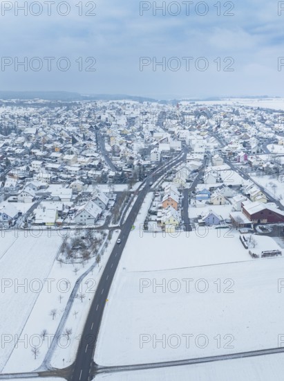 Aerial view of a small snow-covered village surrounded by fields, Deckenpfronn, Böblingen district,