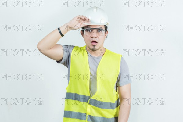 Surprised engineer looking into the distance isolated. Amazed latin engineer looking into the