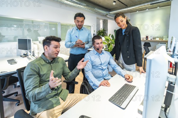 Diverse business team collaborating on a computer project, demonstrating inclusion and teamwork in