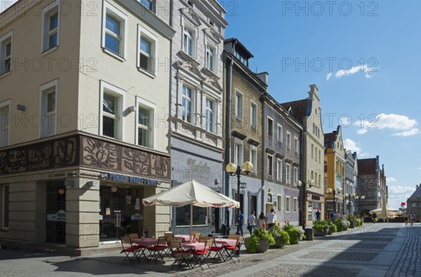Charming old buildings along a quiet, sunny pedestrianised street with cafés, Old Town, Olsztyn,