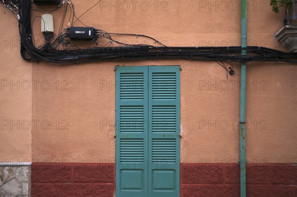 Power lines run outside the house wall, ochre-coloured, Alaró, Calvià, Majorca, Balearic Islands,