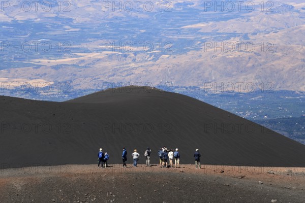 Hikers in the crater landscape of the volcano Etna, summit region, province of Catania, Sicily,
