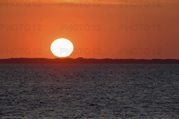 Sunset over the North Sea, on the horizon the contours of the island of Juist, Norddeich, Lower