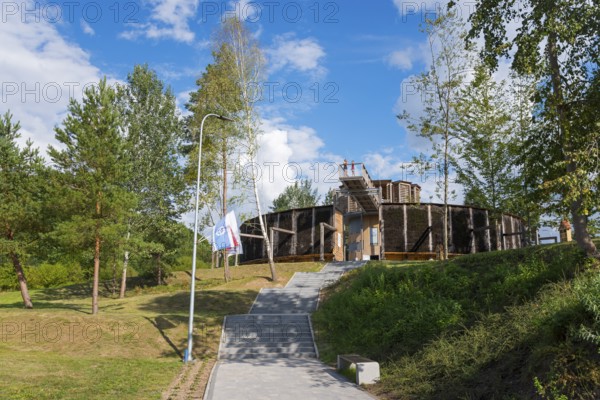 Round wooden building surrounded by trees, in sunny weather and clear sky, brine, graduation tower,