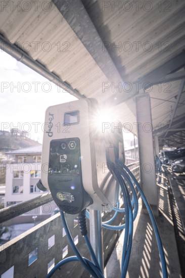 Electric charging station illuminated by sunlight, with blue cables, Kaufland Calw multi-storey car