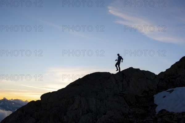 Silhouette of a photographer in front of a blue sky, mountain landscape at sunset, Chamonix,