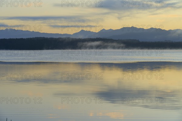 Calm waters with a mountain backdrop under a pastel-coloured sky, Lake Mahinapua, Ruatapu, South