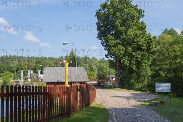 Paved path with trees and view of the lock, sunny summer day, Sluza Kurzyniec, Sluza, lock, border