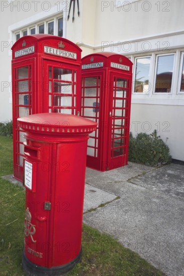 Red telephone boxes and letterbox in front of a British-style building on the Falkland Islands,