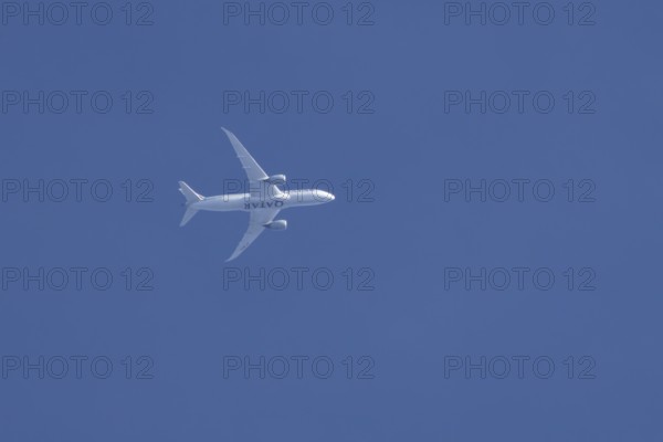 Boeing 787-8 Dreamliner jet aircraft of Qatar airlines flying in a blue sky, England, United