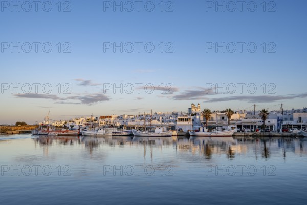 View of Naoussa, Fishing boats in the harbour at sunset, reflected in the sea, White Cycladic