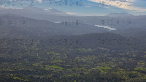 Sky exchanged, Sweeping view of a hilly, green landscape with mountains in the background under a