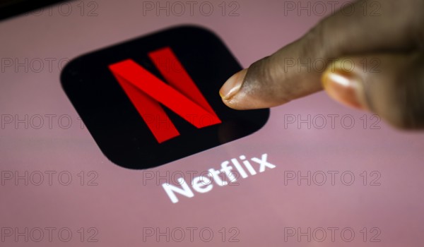 In this photo Illustration a person taps Netflix App icon on a tablet device on 24 May 2025 in New