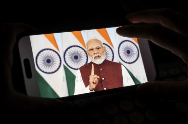 A person watches PM Narendra Modi's address to the nation after Operation Sindoor, on a mobile