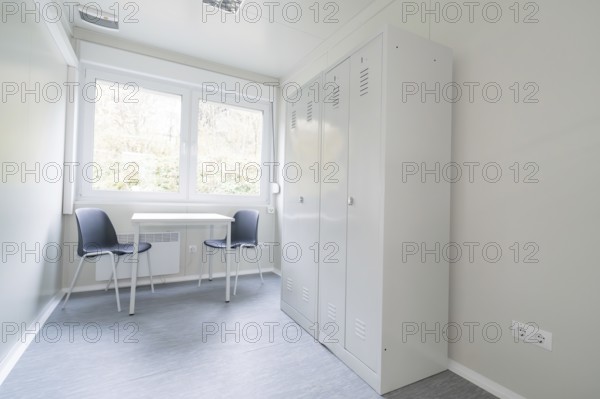 Simple office with desk, two chairs, a cupboard and large window, refugee accommodation Beermiß,