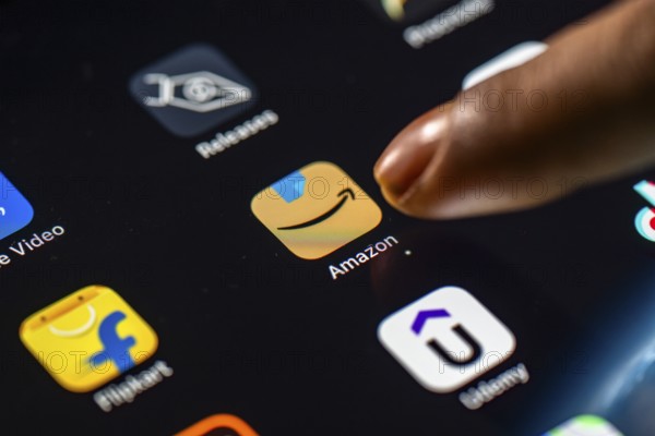 In this photo Illustration a person taps Amazon shopping app icon on a tablet device on 24 May 2025