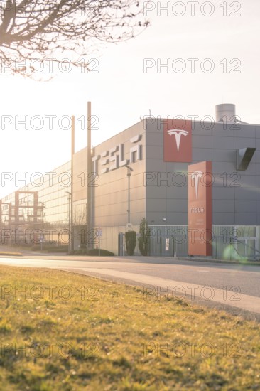 Tesla production facility in the sunset with grey building and modern logo, Tesla, Holzgerlingen,