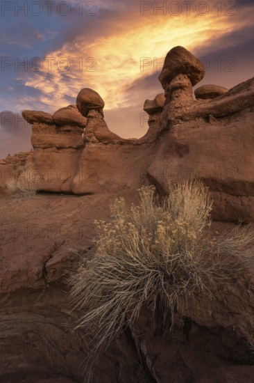 Stunning sandstone formations at Goblin Valley State Park, Utah, bask under a dramatic sunset. The