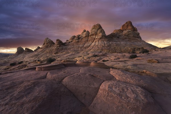 A majestic sunset casts warm colors over the unique sandstone formations at Coyote Buttes, located