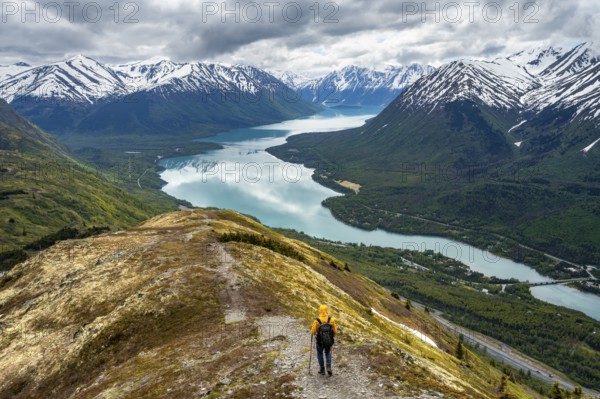 Climbers on a hiking trail on Slaughter Ridge, views of snowy mountains in spring and turquoise