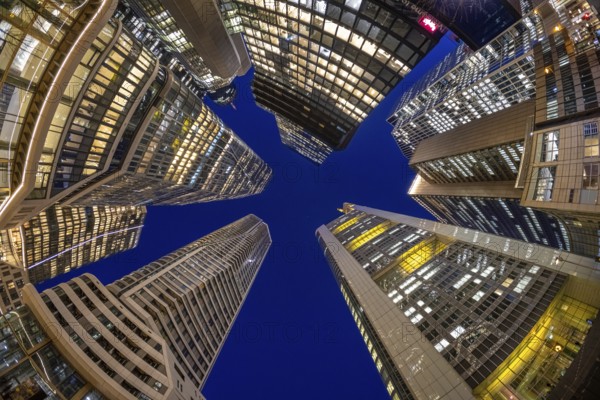 The glowing skyscrapers of Frankfurt's banking skyline rise into the blue evening sky, Frankfurt am