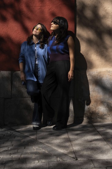 A multiethnic lesbian couple shares an intimate moment outdoors, exuding warmth and unity. The